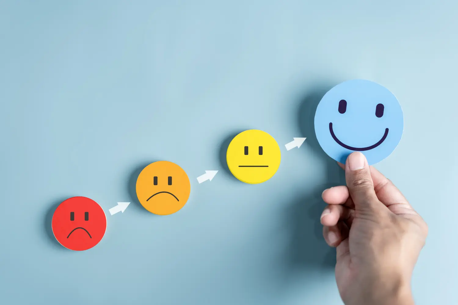 Hände, die ein blaues, glückliches Lächeln für das medizinische Versorgungskonzept halten. Positives Denken zur psychischen Gesundheit.